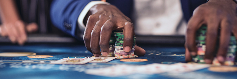 Close-up of a dealer stacking colorful chips on a casino table with playing cards visible