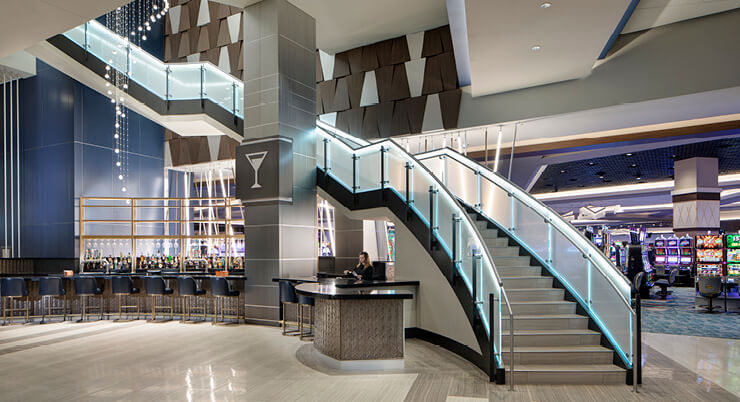 View of the casino featuring slot machines, the bar area, and a large staircase