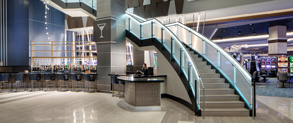 View of the casino featuring slot machines, the bar area, and a large staircase