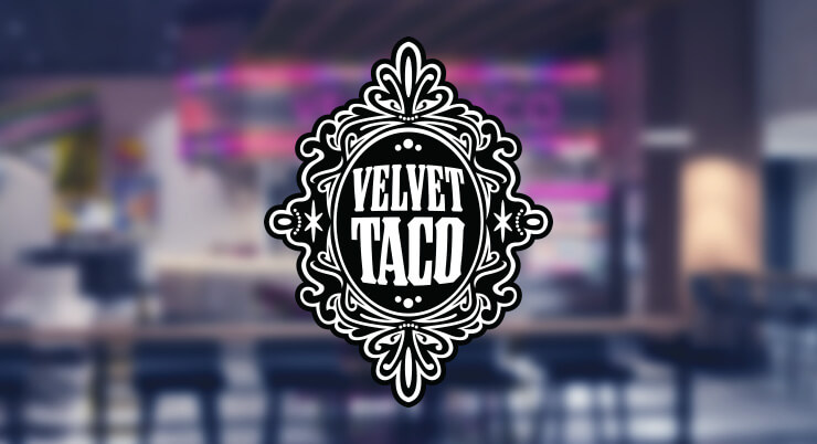 Velvet Taco crest logo over a blurred view of the storefront.