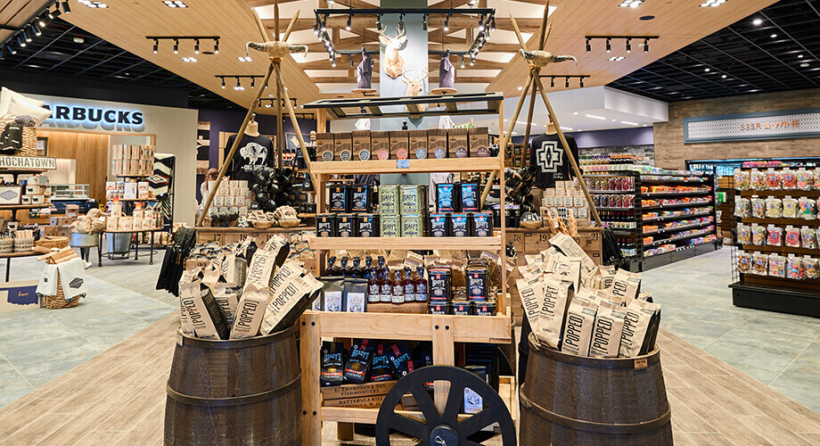 The Mercantile market interior with rustic displays of snacks and gifts; Starbucks sign visible in the background
