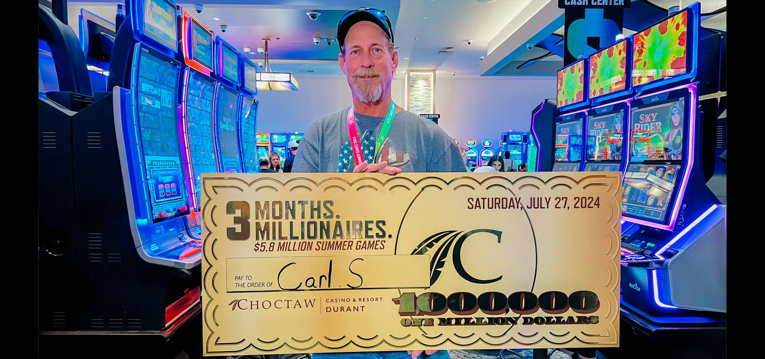 Winner in the slot area holding an oversized $1,000,000 check reading ‘3 Months. Millionaires.’