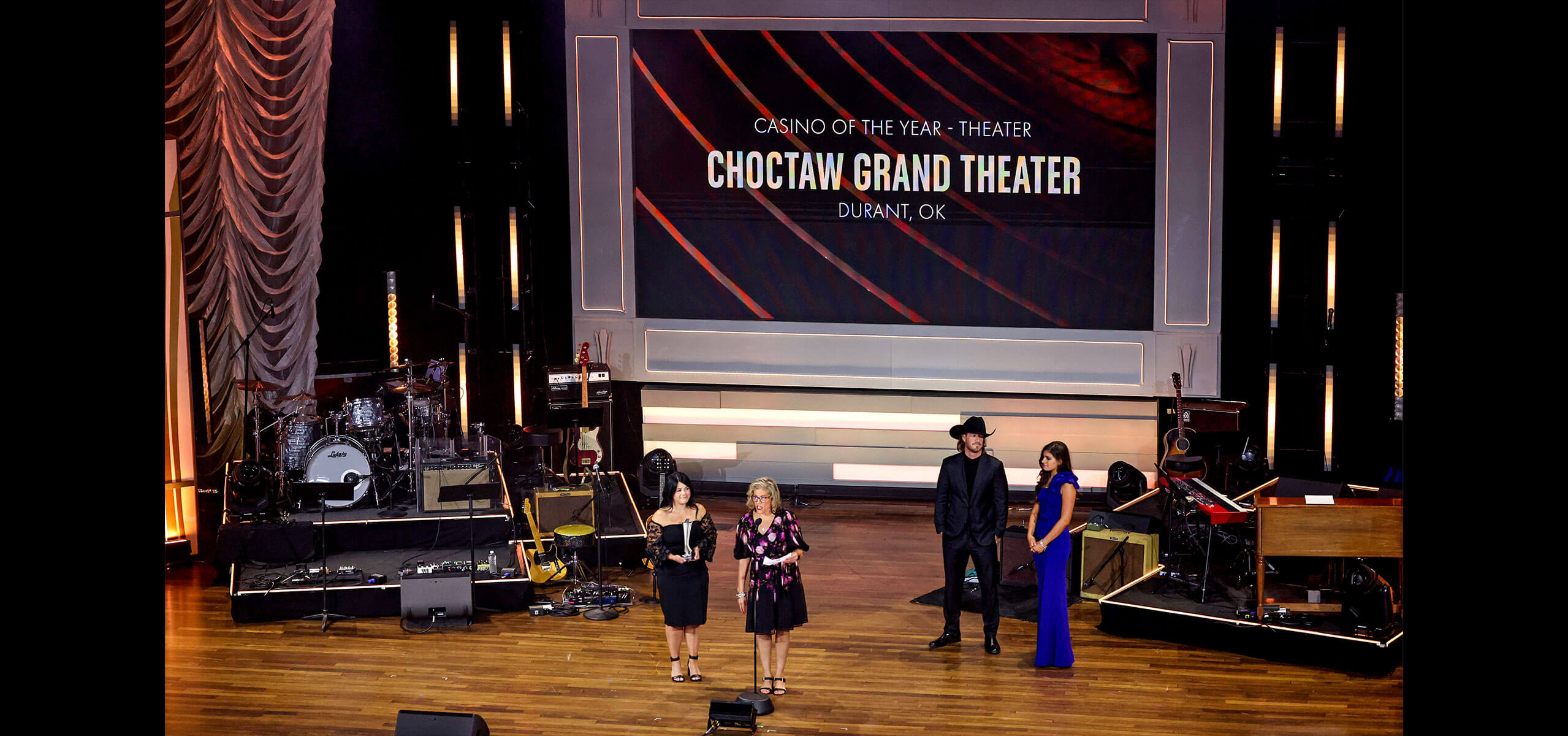 Awards stage with four presenters in front of a screen that reads ‘Casino of the Year – Theater: Choctaw Grand Theater, Durant, OK,’ band setup flanking both sides
